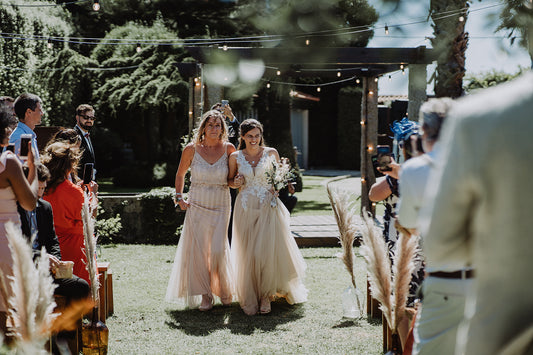 Bride Jade, walking down the isle with her Mum, wearing their second hand wedding outfits.
