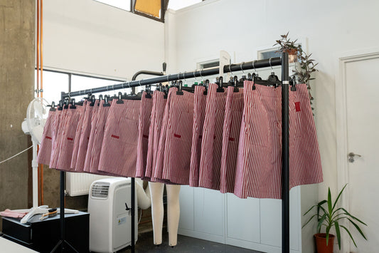 Saywood's Bessie Aline Shorts in Berry Red Stripe production can be seen hanging on a rail in MAES, the London factory. Handmade in the UK