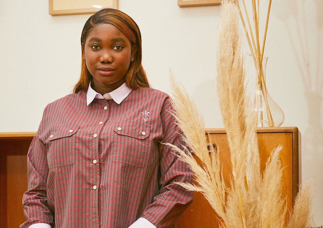Womens Shirts Saywood Jules Shirt made from deadstock cotton. Model sits against mid century cupboard with pampas grass off to the side