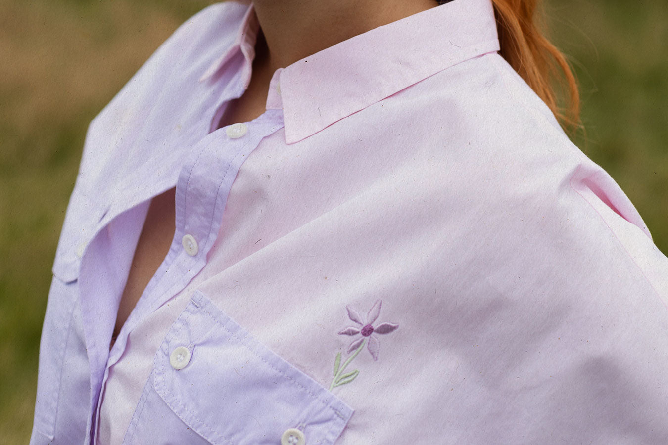 Close up of Saywood's signature flower embroidery on the Jules Utility Shirt in pink and lilac. The flower is just above the utility pocket on the chest