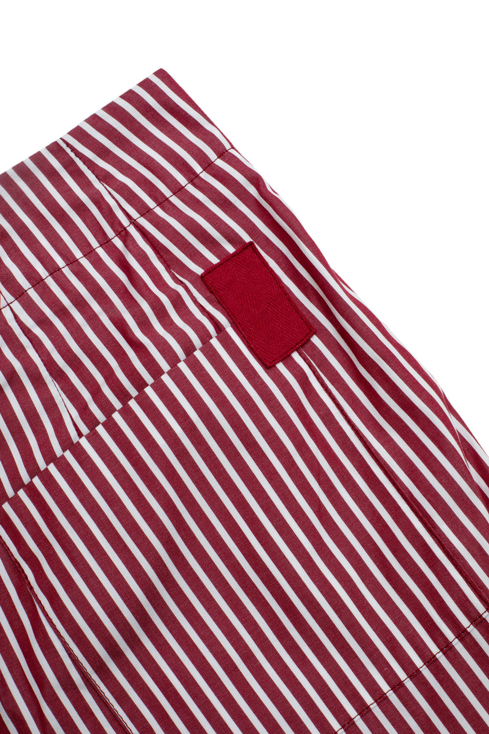 Close up flat shot of the Bessie A-line Shorts in berry red stripe, back pocket detail with berry red cotton herringbone tape tab detail.