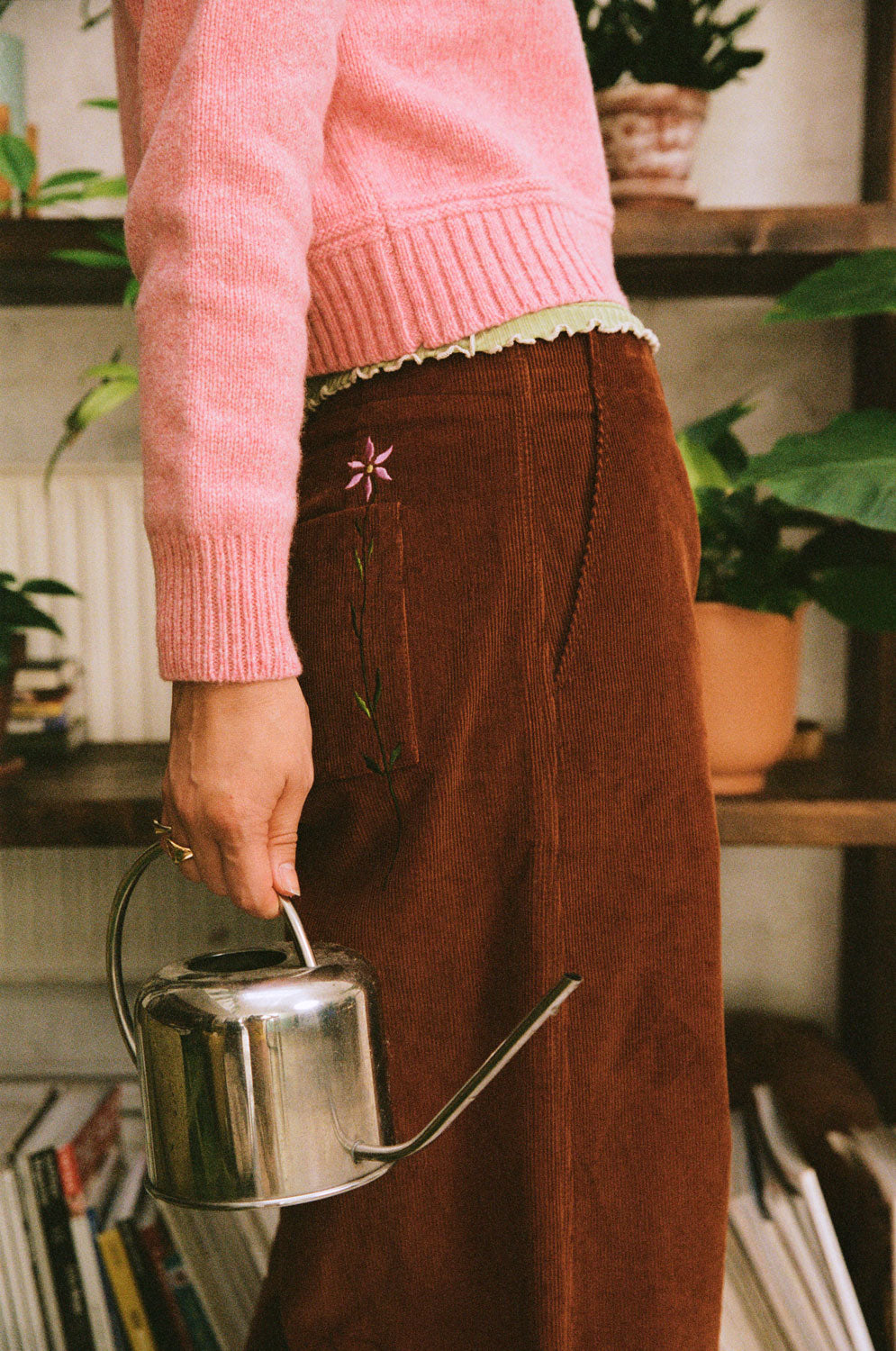 Side close-up of Amelia caramel corduroy trousers, showing an embroidered flower, patch pocket and topstitching