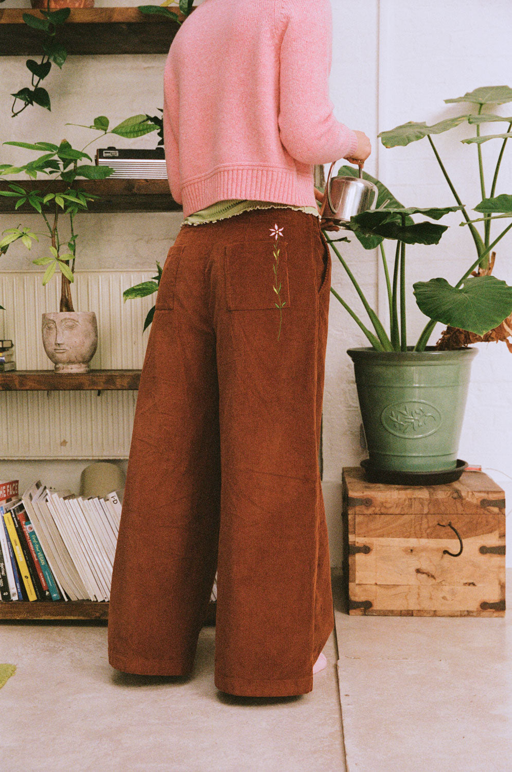 Full-length rear view of Amelia caramel wide-leg corduroy trousers, styled with a pink sweater.