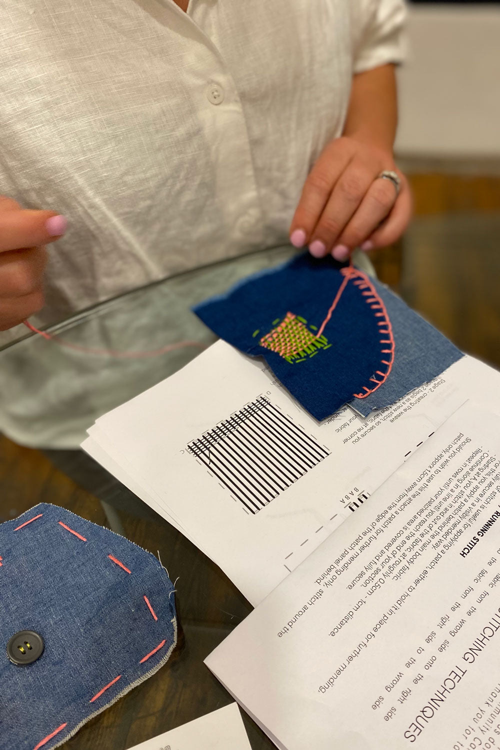Workshop participant practicing mending skills with fabric swatches