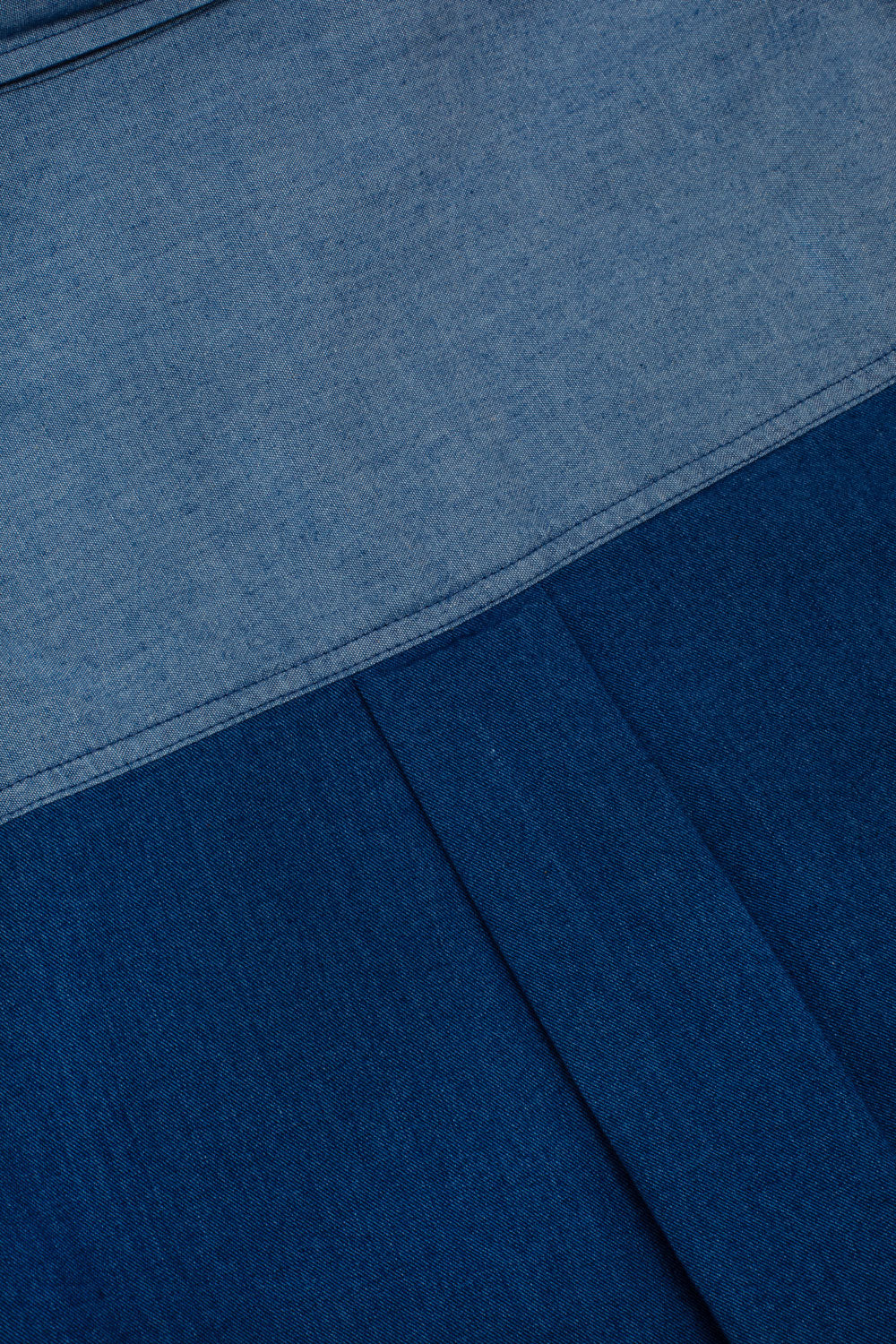 Close-up of blue fabric contrast and texture with pleated at back yoke