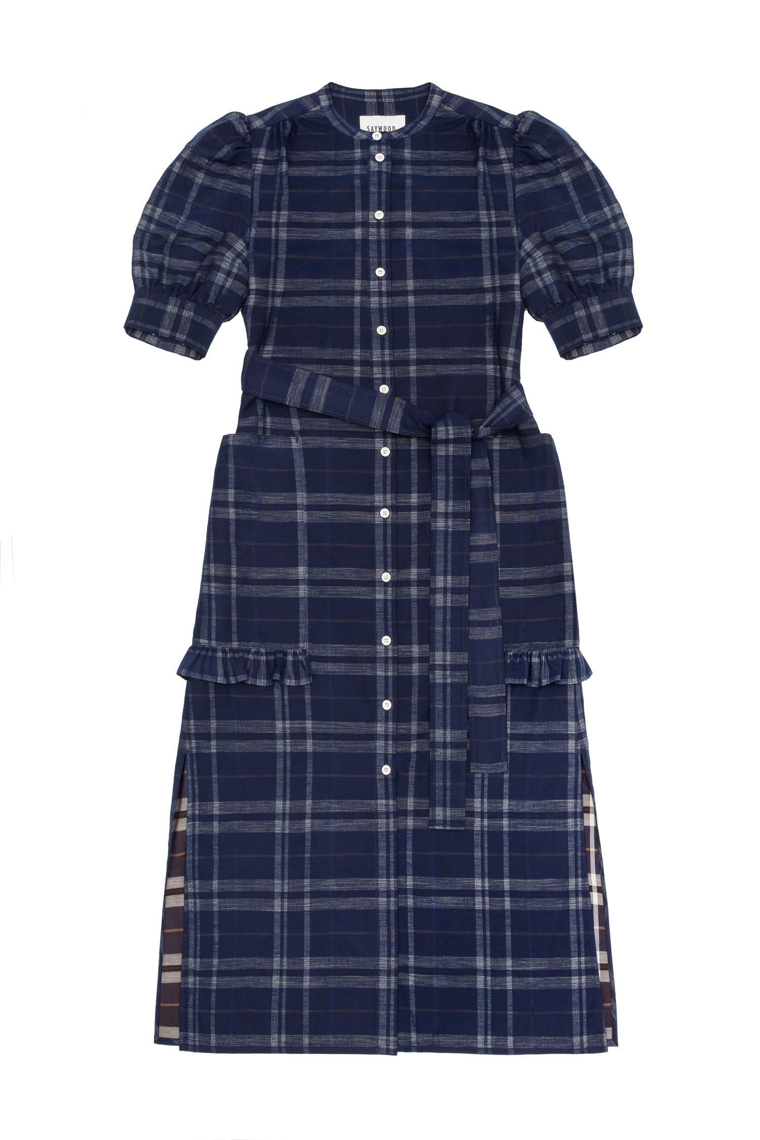 Womens navy check puff sleeve dress, long line with side splits at the hem. The Rosa Dress by Saywood has patch pockets at the hip with ruffles at the bottom of the pockets, with a tied matching belt around the waist. Dress is on a white background.