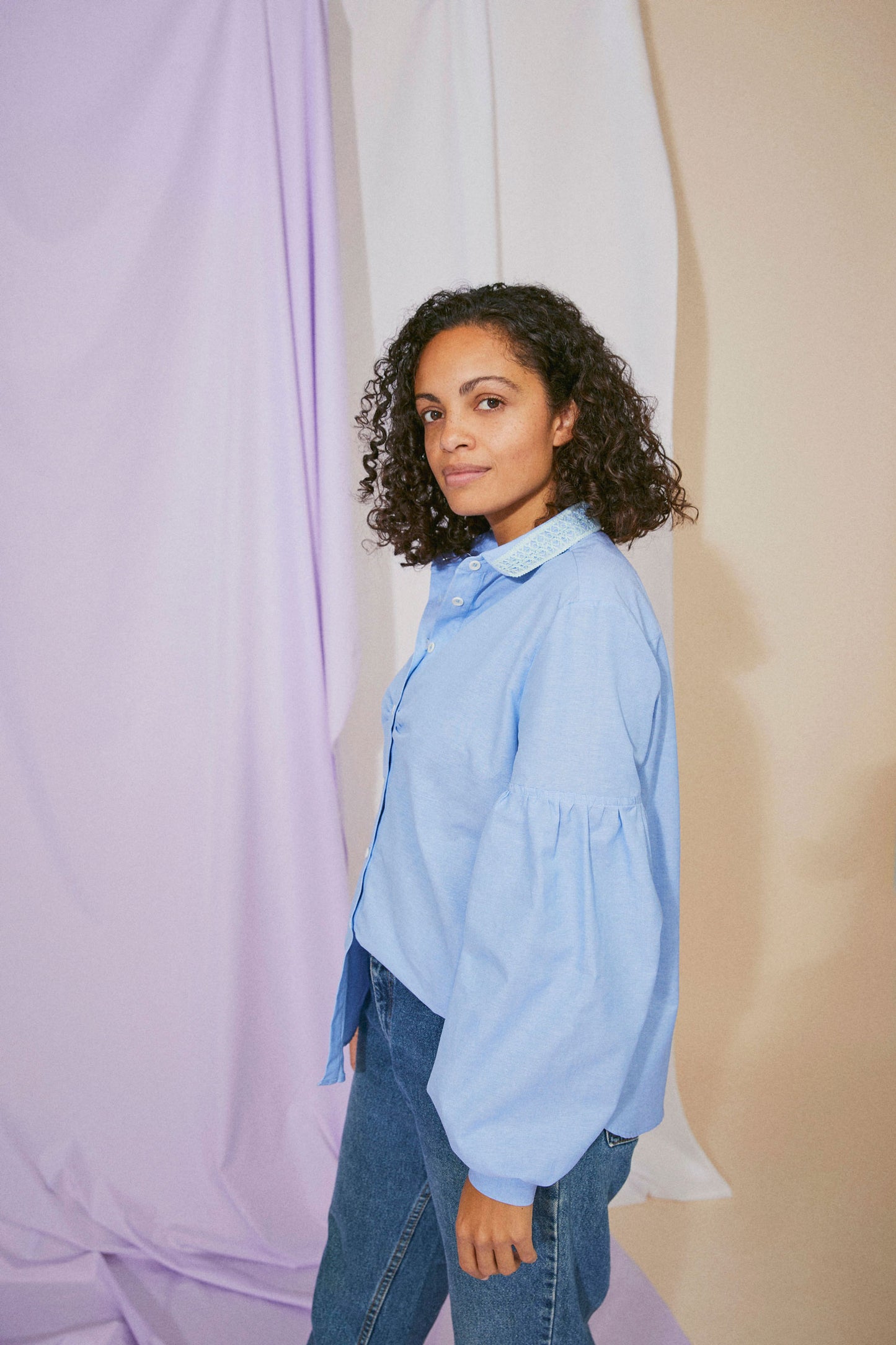 Womens pale blue shirt in recycled cotton, with lace collar trims, volume sleeves, and soft gathers at the bust, side view
