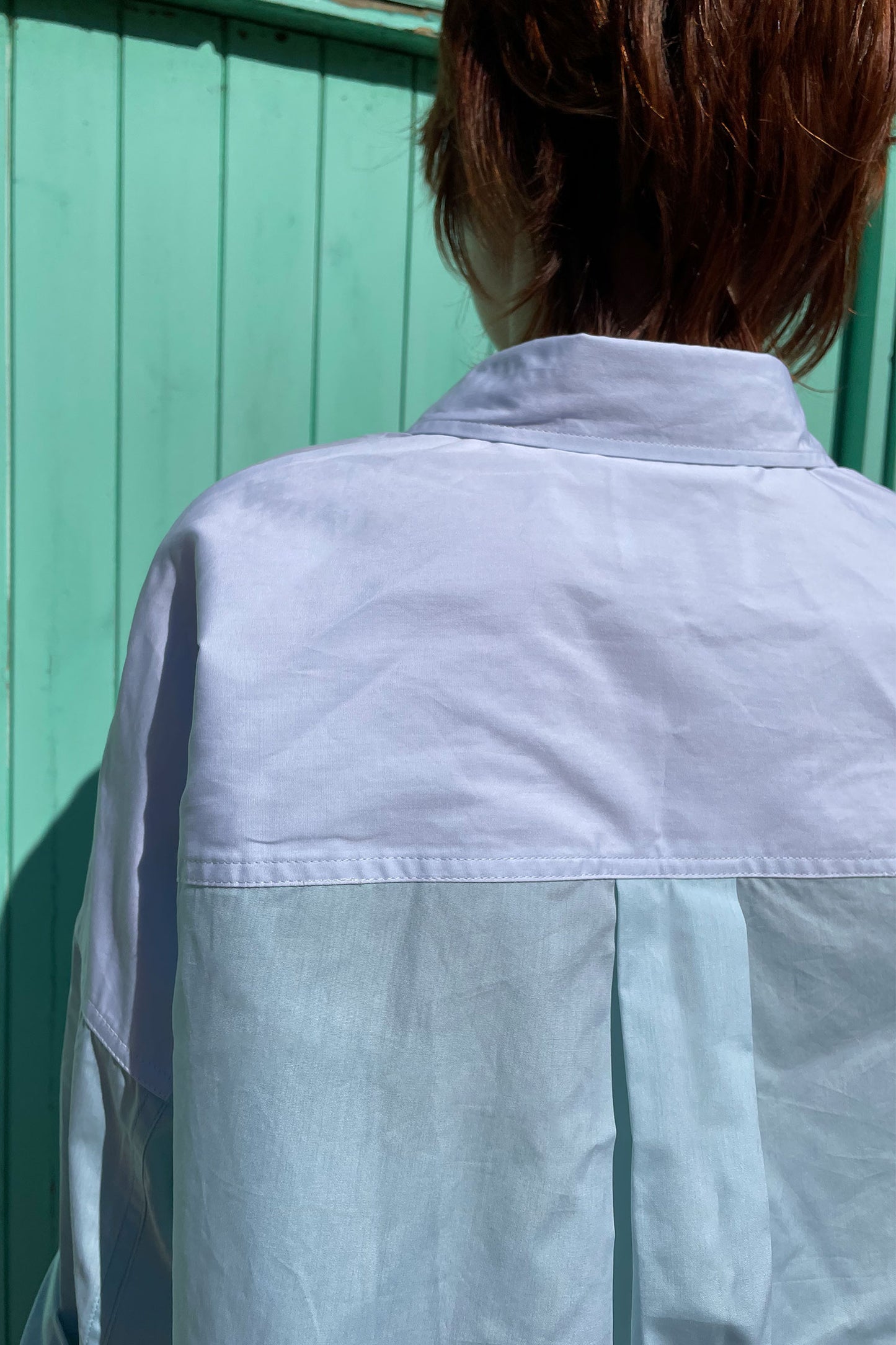 Close up of back of the Saywood pastel green and blue colourblock Lela Boxy Shirt in cotton. With contrasting front body panels and pockets. Back neck yoke is in soft blue, contrasting with the back body which is in green. Made in the UK