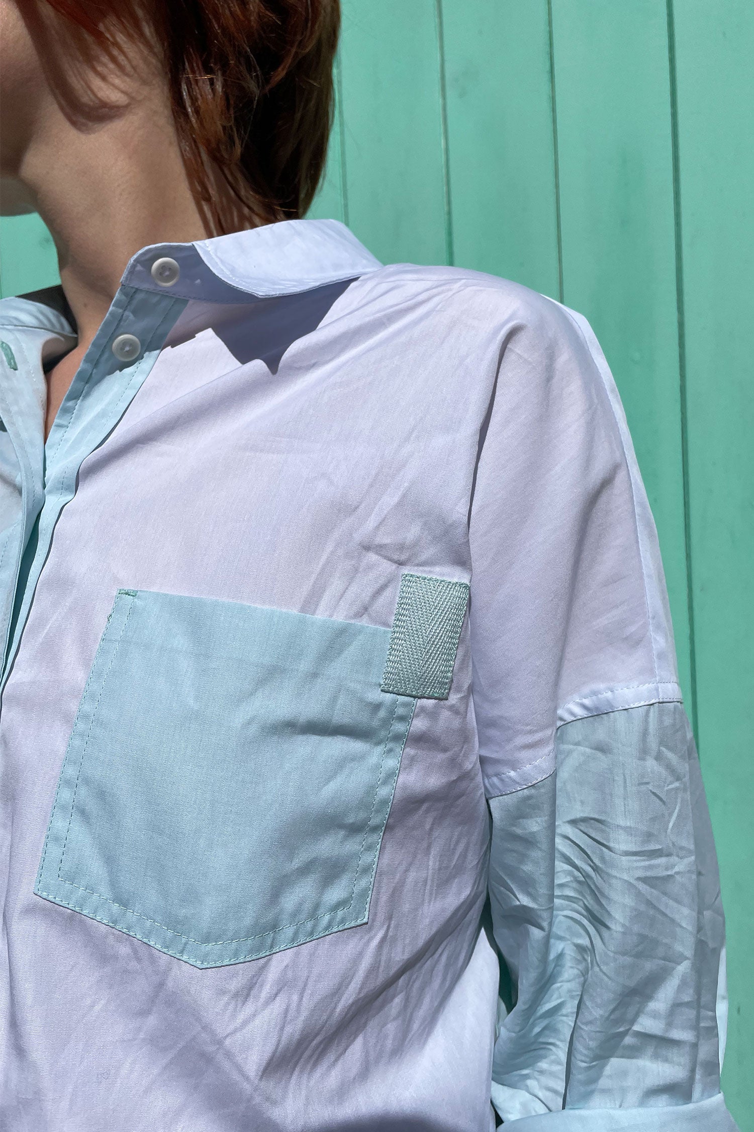 Close up of pocket on the Saywood pastel green and blue colourblock Lela Boxy Shirt in cotton. With contrasting front body panels and pockets. Pocket is contrasting against the body panel, with a green cotton herringbone tape stitched on the pocket corner. Made in the UK