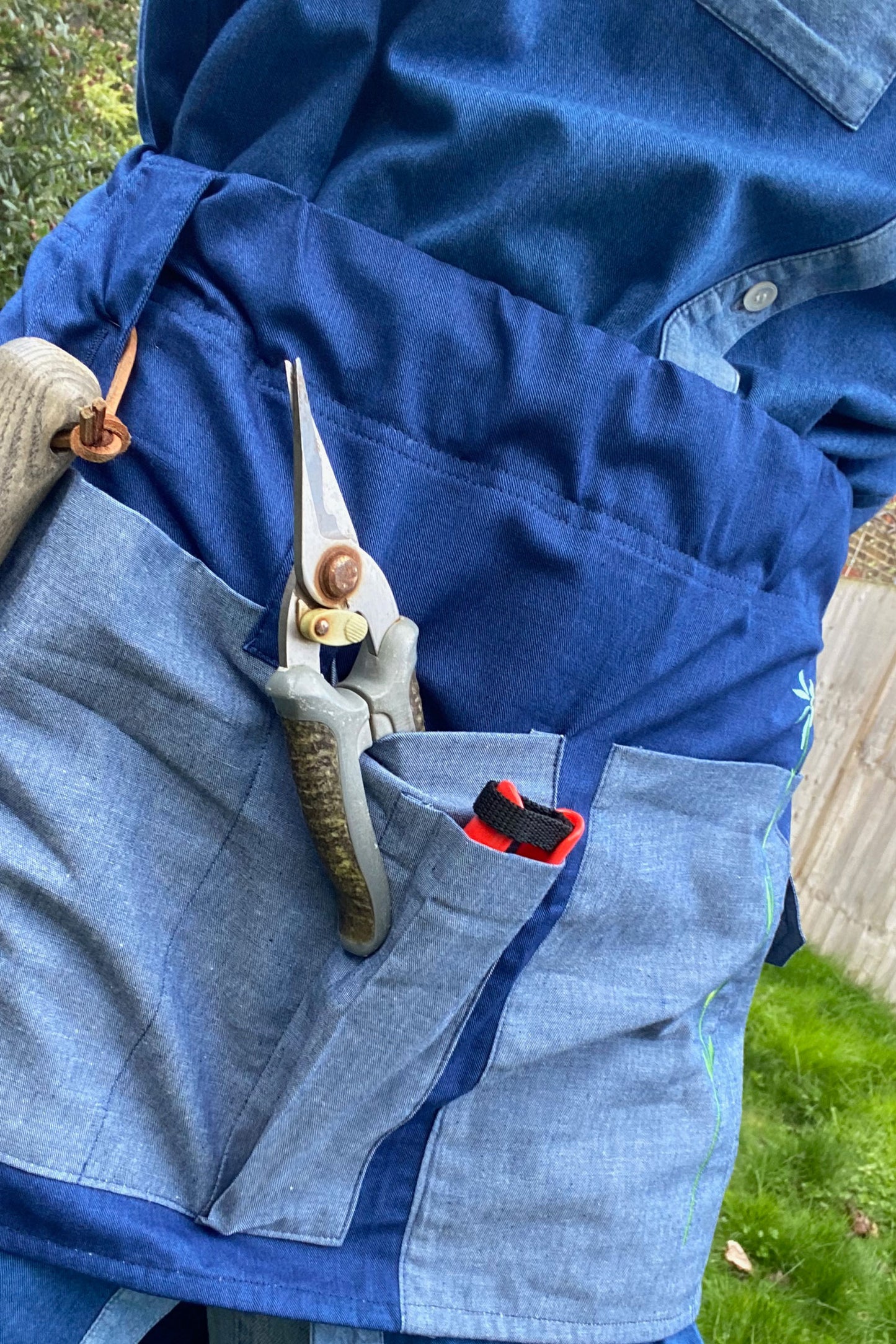 Tool Belt made in Japanese Denim, for the garden or multifunctional, by Saywood. Tool belt is being worn in the garden with gardener's tools in the pockets.